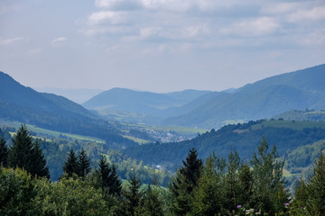 Fototapeta na wymiar western carpathian Tatra mountain skyline with green fields and forests in foreground