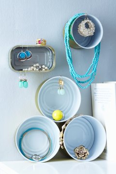 Assorted tin cans on the wall being used a jewelery boxes