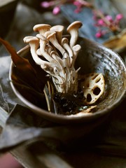 Close up of enoki mushrooms and lotus roots in bowl