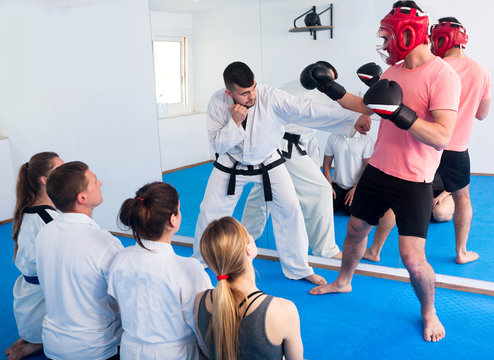 Coach explaining painful hold in taekwondo class