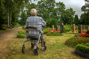 An old woman goes with her walking frame on the graveyard to be there with her survivors. Concept:...