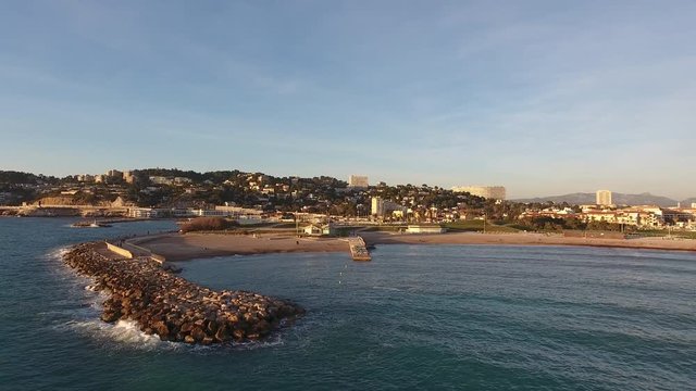 Zoom out over Marseille beach during sunset with seagull