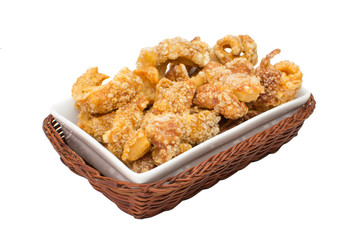 Pork crackling  traditional Brazilian recipe called torresmo in a platter isolated in white background