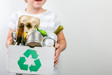 Boy holds box with recyclable materials