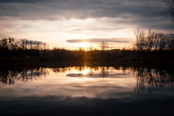 Fototapeta premium Twilight fog on the lake during sunset with reflection on the water that was completely calm...