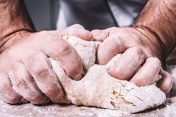 male chef kneads the dough