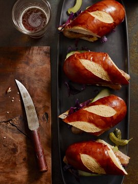 Lye bread rolls with red cabbage and gherkins served on plate