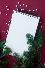 Blank notebook on red background with xmas decorations, copy space.