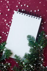 Top view of blank notebook on red background with xmas decorations, copy space.