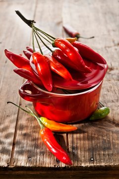 Chilli peppers in a red hot or wooden table