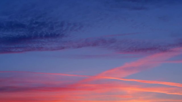 Amazing time-lapse with last moments of evening blue sky with pink and red  clouds. Quickened motion of heaven vapor on limitless space. Abstract natural background with tranquil effect.