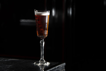 kir royal on a bar desk. black background.
