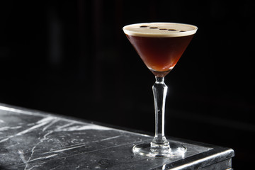 Espresso Martini cocktail on a bar desk. black background.