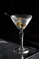 Dry Martini cocktail on a bar desk. black background