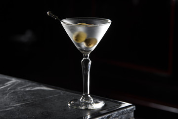 Dry Martini cocktail on a bar desk. black background