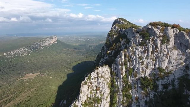 Beautiful cliff of the mountain pic saint loup with valley in background. Aerial drone shot sunny day