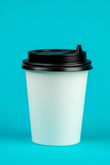 Paper coffee container with black lid on blue background. Take-away beverage container. Drink Cup template for your design.