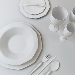Abstract illustration of a set of dishes in white colors. Plates, glasses, spoons, fork, knife on the table. 3D illustration.