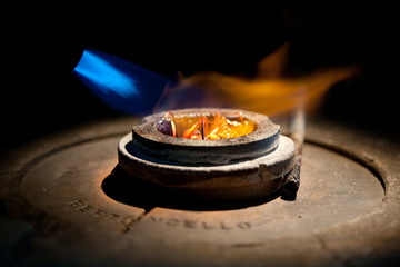 melting golden metal in furnace with fire for making jewelry