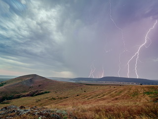 Naklejka na ściany i meble Thunderstorm with lightnings over the fields