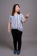 Full length portrait of Japanese businesswoman against gray background