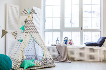 Stylish modern children room. Kid's wigwam in children room. Large wooden star lamp. Interior scandinavian style. © Angelov