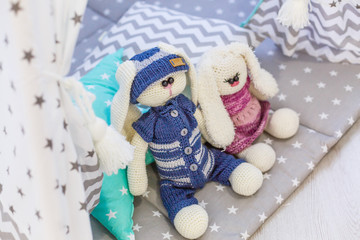 Two handmade rabbit toys male and female. Baby shower decoration ideas. DIY knitted toys for kids