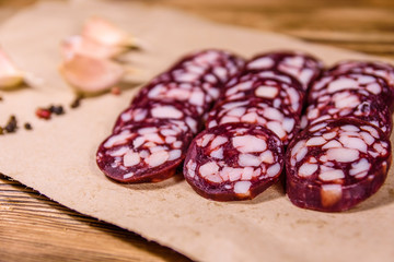 Sliced salami sausage and garlic on a brown wrapping paper