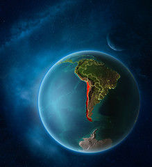 Planet Earth with highlighted Chile in space with Moon and Milky Way. Visible city lights and country borders.