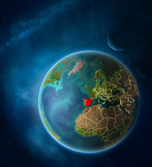 Planet Earth with highlighted Spain in space with Moon and Milky Way. Visible city lights and country borders.