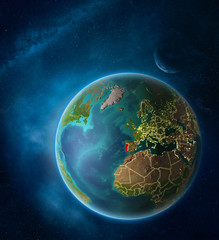 Planet Earth with highlighted Portugal in space with Moon and Milky Way. Visible city lights and country borders.