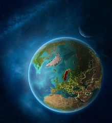 Planet Earth with highlighted Sweden in space with Moon and Milky Way. Visible city lights and country borders.