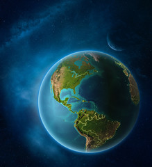 Planet Earth with highlighted Puerto Rico in space with Moon and Milky Way. Visible city lights and country borders.