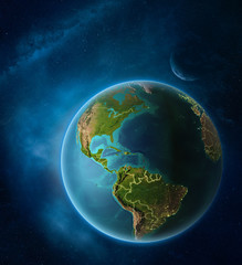 Planet Earth with highlighted Caribbean in space with Moon and Milky Way. Visible city lights and country borders.