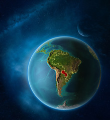 Planet Earth with highlighted Paraguay in space with Moon and Milky Way. Visible city lights and country borders.