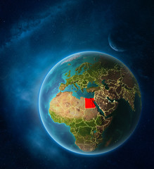 Planet Earth with highlighted Egypt in space with Moon and Milky Way. Visible city lights and country borders.