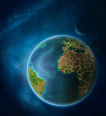 Planet Earth with highlighted Sierra Leone in space with Moon and Milky Way. Visible city lights and country borders.