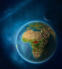Planet Earth with highlighted Central Africa in space with Moon and Milky Way. Visible city lights and country borders.