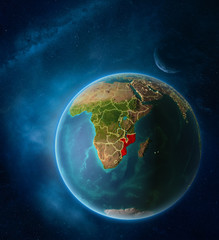 Planet Earth with highlighted Mozambique in space with Moon and Milky Way. Visible city lights and country borders.