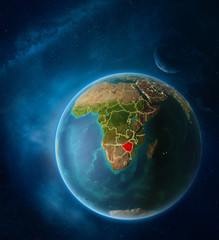 Planet Earth with highlighted Zimbabwe in space with Moon and Milky Way. Visible city lights and country borders.
