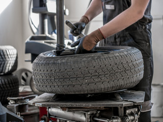 Wheel whit summer tire on tire changing machine in a workshop. Wheel on tire changing machine.