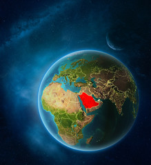 Planet Earth with highlighted Saudi Arabia in space with Moon and Milky Way. Visible city lights and country borders.