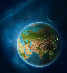 Obraz na płótnie Canvas Planet Earth with highlighted Kyrgyzstan in space with Moon and Milky Way. Visible city lights and country borders.