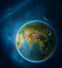 Planet Earth with highlighted Bangladesh in space with Moon and Milky Way. Visible city lights and country borders.
