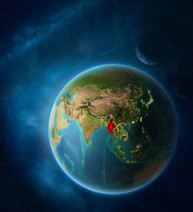 Planet Earth with highlighted Myanmar in space with Moon and Milky Way. Visible city lights and country borders.