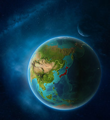 Planet Earth with highlighted Japan in space with Moon and Milky Way. Visible city lights and country borders.