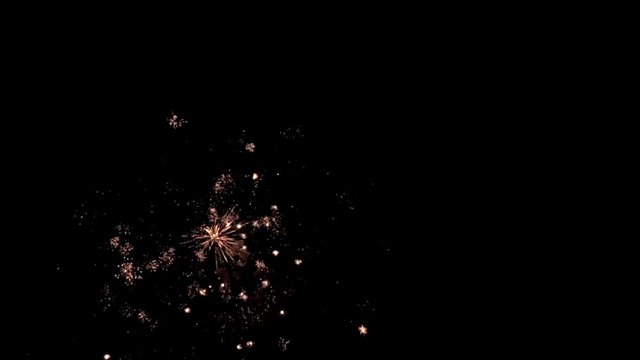 Bright colorful fireworks turn to multicolor bokeh lights at holiday dark summer night.