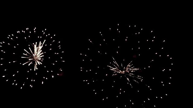 Bright colorful fireworks turn to multicolor bokeh lights at holiday dark summer night.