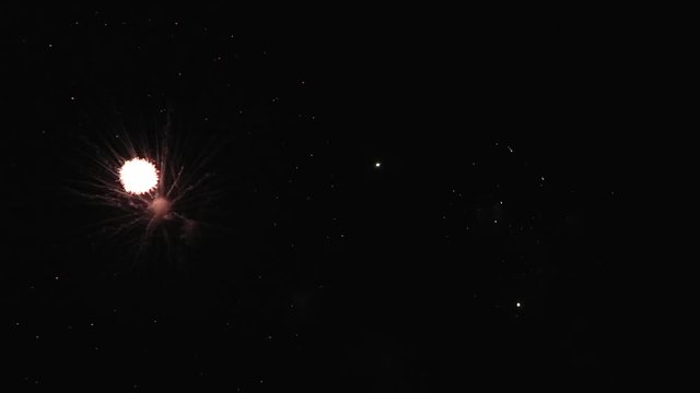 Bright colorful fireworks turn to multicolor bokeh lights at holiday dark summer night.