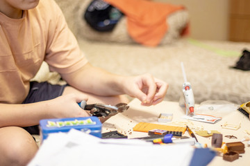 Fototapeta na wymiar hands of the boy close-up making crafts5.jpg